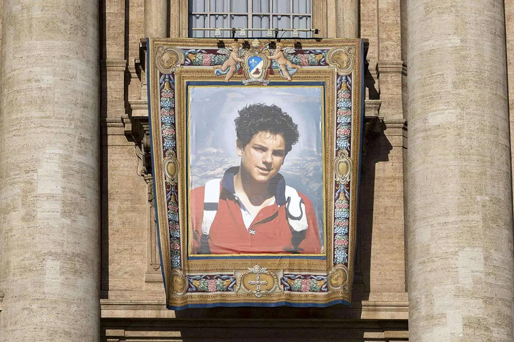 Tapiz oficial con el retrato de san Carlo Acutis colgado en la fachada de la Basílica de San Pedro en el Vaticano durante la ceremonia de su canonización.
