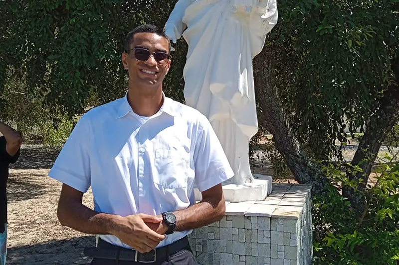 Guilheme Silva de Araujo in posa per una foto con occhiali da sole e camicia bianca.