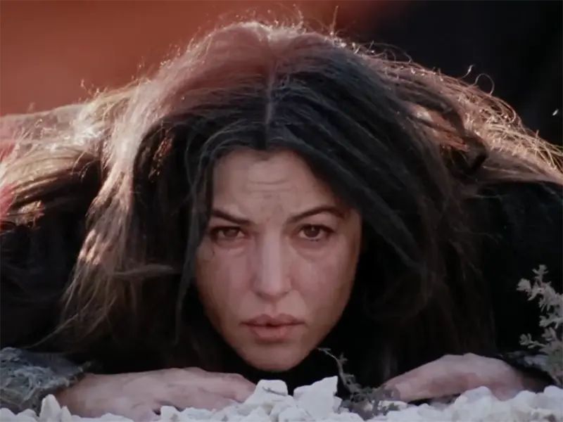 Maria Magdalena cu o expresie angoasată, întinsă pe pământ. Scenă din Patimile lui Hristos, de Mel GIbson.