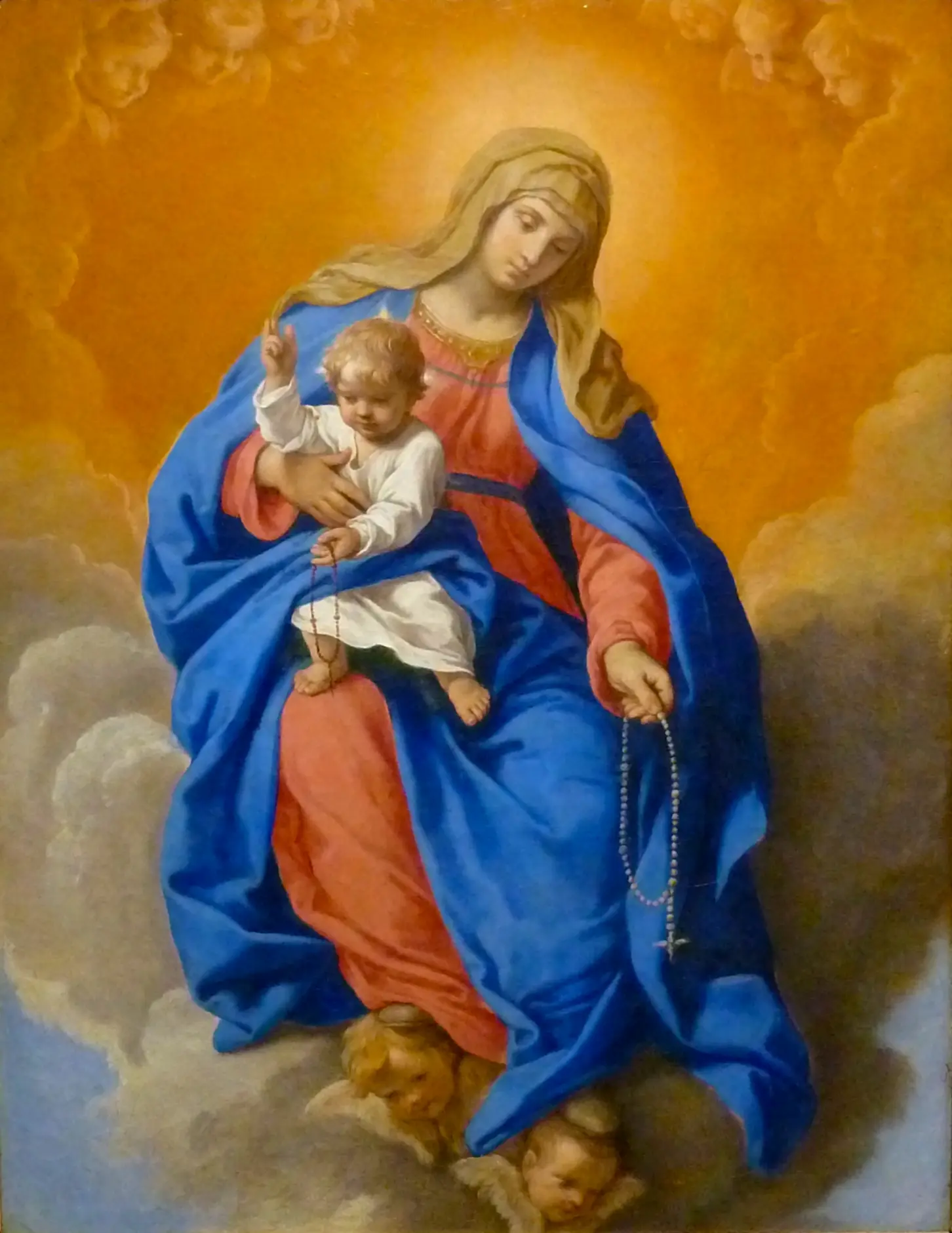 Una imagen de la Virgen María del Rosario sosteniendo al Niño Jesús, ambos coronados y rodeados de un aura celestial para conmemorar el mes de octubre