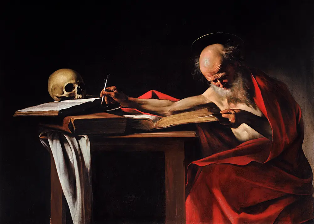San Jerónimo, con el torso desnudo y un manto rojo, se inclina sobre un escritorio para escribir la traducción de la Biblia, iluminado por una intensa luz lateral en una obra de Caravaggio.